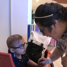 Image of young adult talking to young child with WAGR syndrome