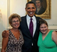 Amy and Shari standing with President Obama (his arms are around them both)