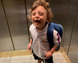 Image of child smiling with a backpack
