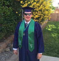 Boy with WAGR syndrome smiling, wearing a graduation cap and gown